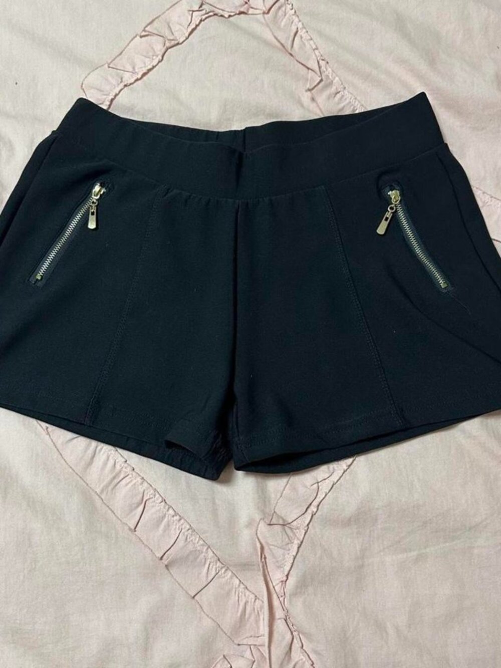 Black shorts with gold zipper details.